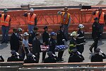 In a solemn, worldless ceremony marking eight months of cleanup from the terrorist attacks of September 11, 2001, which destroyed the twin towers of the World Trade Center, an empty stretcher is carried up the ramp from the pit, and the last steel column is carried out on a truck. An honor guard of police, firefighters, contruction workers, rescue personnel, and military lined the ramp. Families of victims were present as was Mayor Michael Bloomberg.