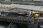 In a solemn, wordless ceremony marking the end of eight monyhs of cleanup from the terrorist attacks of September 11, 2001 which destroyed the twin towers of the World Trade Center, an empty stretcher is carried up the ramp from the pit, and the last steel column is carried out on a truck. An honor guard of police, firefighters, construction workers, and rescue personnel lined the ramp. Familes of victims were present as was Mayor Michael Bloomberg.