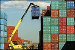 Shipping containers piled high in depots near ports in the U.S.A. illustrate America's trade deficit. Near Port Newark, New Jersey, container depots use special equipment to stack containers up to eight (8) high. Trucks drop off empty containers for storage or pick up empty ones for use. Depots resemble cities or monuments, blocking the skylines of Newark, N.J., and New York City.