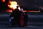 Family of oil worker looking at burning oil wells a few hundred meters from their home. Al Ahmadi, Kuwait