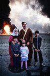 Family of oil worker looking at burning oil wells a few hundred meters from their home. Al Ahmadi, Kuwait