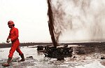 U.S. Oil Well firefighters from Boots and Coots of Texas extinguish their first oil well fire in Al Ahmadi, Kuwait