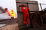 U.S. Oil Well firefighters from Boots and Coots of Texas extinguish their first oil well fire in Al Ahmadi, Kuwait