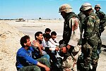 U.S. troops check I.D.'s of Arabs outside Safwan, Iraq, on the Kuwait City-Basra road.