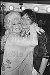 Country music star Dolly Parton hugs rock star Mick Jagger backstage after her Bottom Line concert.<br>NYC 5/14/77<br>1554-5<br>From SoHo Blues - A Personal Photographic Diary of New York City in the 1970s by SoHo Weekly News chief photographer Allan Tannenbaum