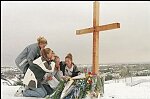 High School Girls place flowers at cross erected on hill overlooking Columbine High School, Littleton, CO, April 23, 1999