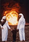 A Kuwaiti family surveys the oil fields set ablaze by Saddam Hussein after his defeat in the Gul War. Kuwait, 1991